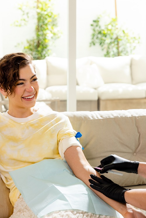 Woman smiling receiving IV therapy